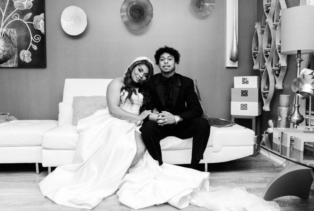 Bride and groom sitting on couch for couples portrait. Black and White