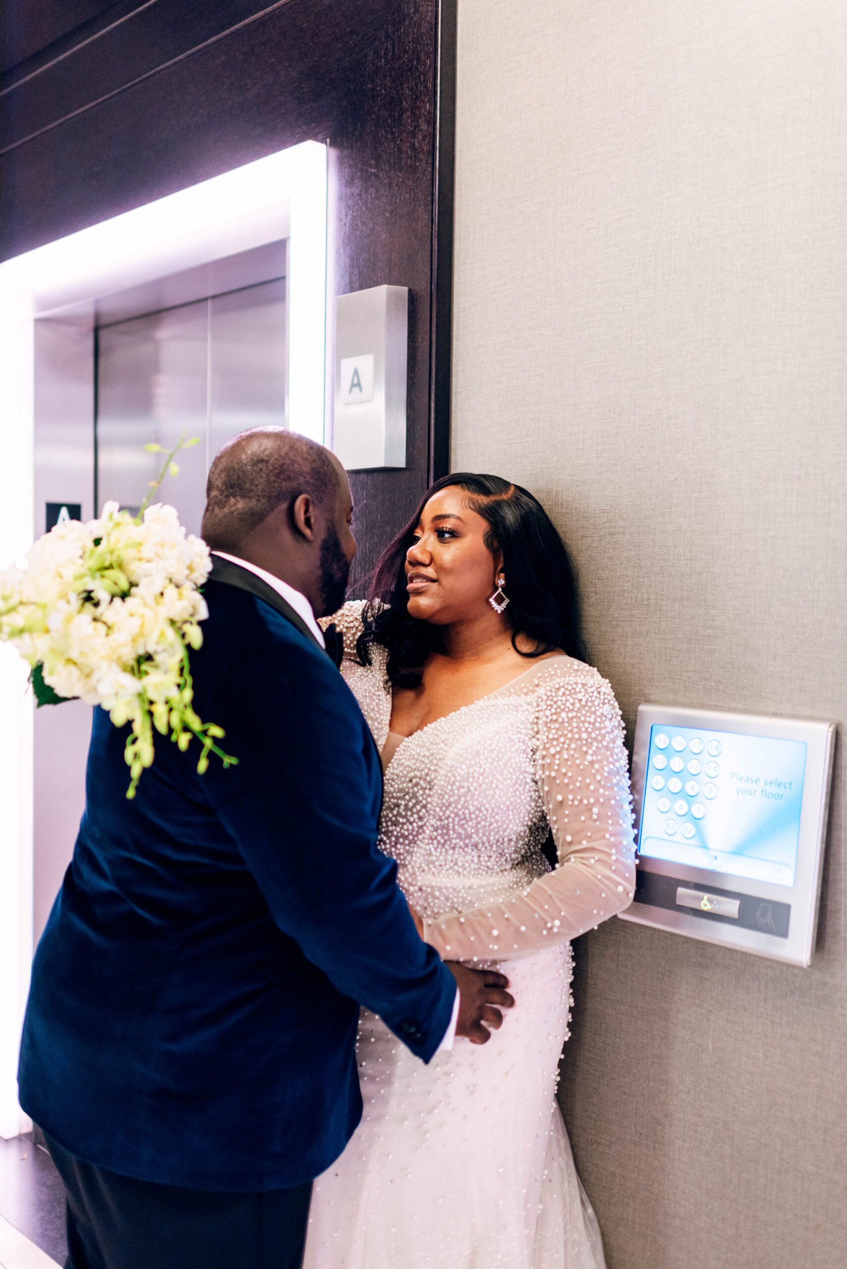 Bride and groom in front of elevator in Kimpton Tryon Park hotel
