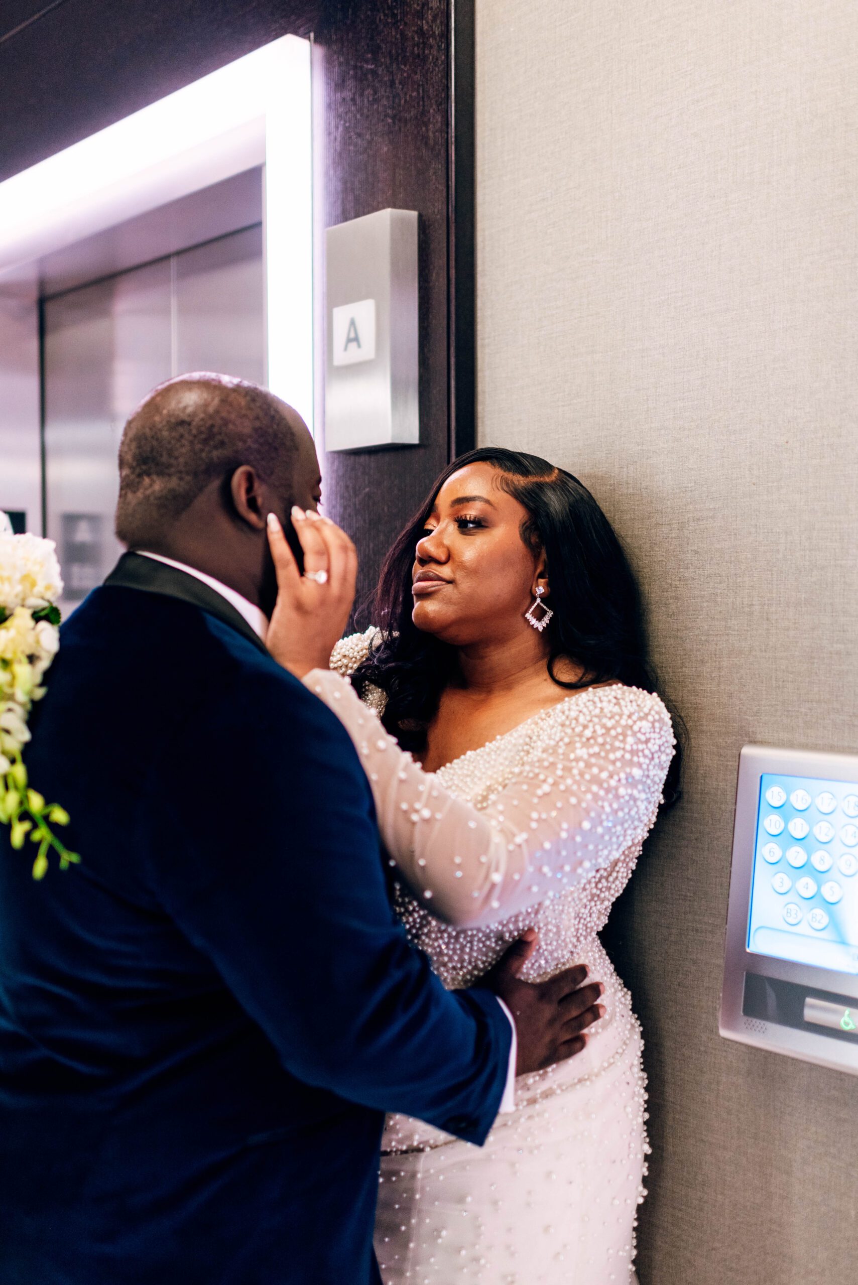Bride and groom in front of elevator in Kimpton Tryon Park hotel