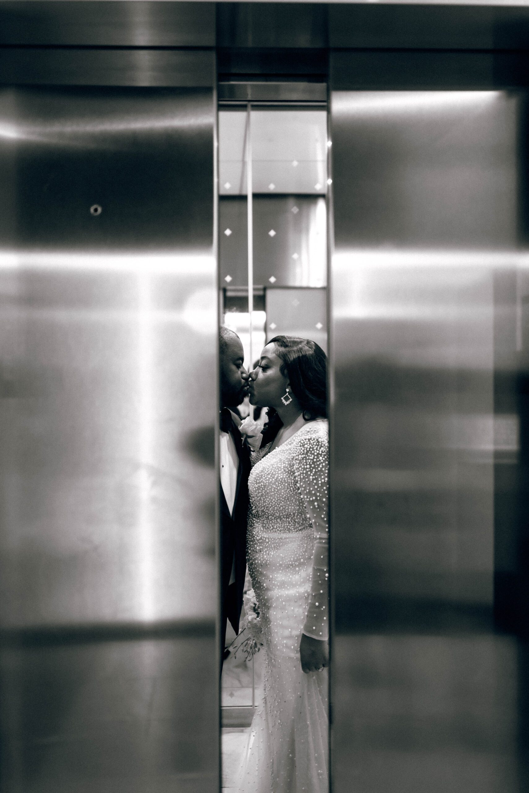 Bride and groom in kissing in elevator in Kimpton Tryon Park hotel